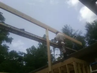Carpenter setting a ridge beam over a new addition frame — Ice Dam Removal by Roofing Brothers in Grabill