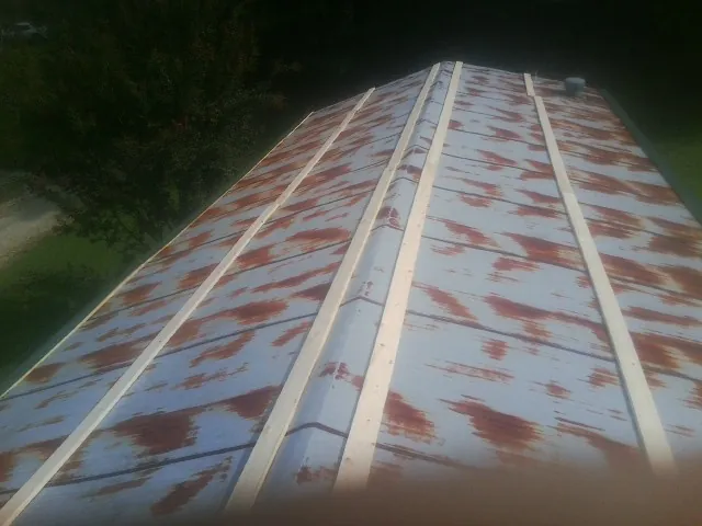 Rusted metal roof panels with new wood purlins before replacement — Storm Damage Roof Repair in Grabill by Roofing Brothers